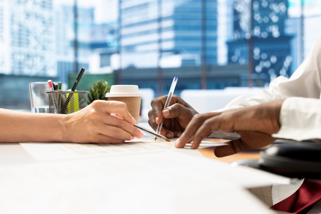 Close up of employer offering man internship deal, signing contract