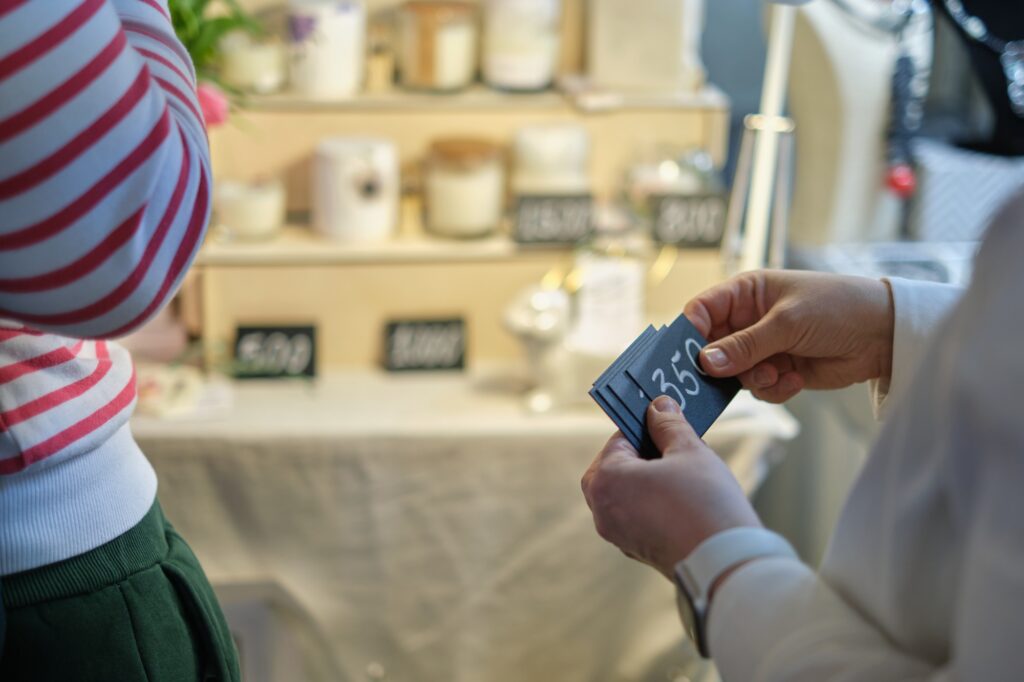 female business owner places pricing labels on her unique wares. The image captures the less