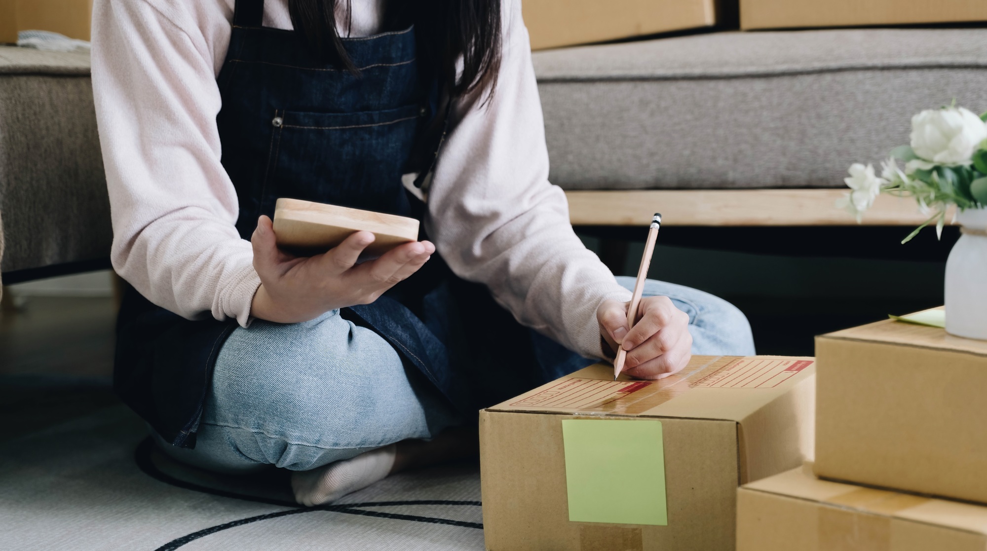 Startup Entrepreneurship Small Business SME Freelance Young lady working at home with boxes on the